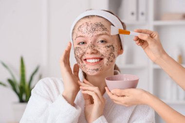 Güzellik salonunda chia tohumu maskesi alan mutlu genç bir kadın.