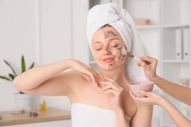 Güzellik salonunda chia tohumu maskesi alan genç bir kadın.