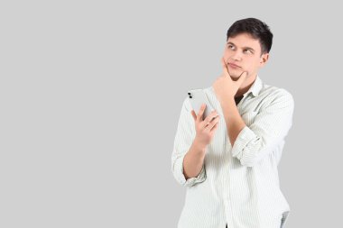 Arka planda cep telefonu olan genç bir adam.