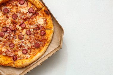 Beyaz zemin üzerinde lezzetli pizzalar olan karton kutu.