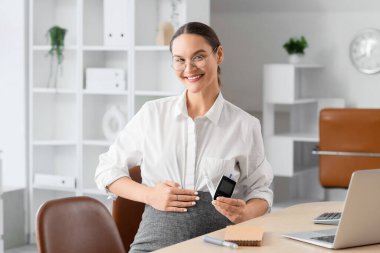 Ofisteki masada gebelik diyabeti ve glukometresi olan genç hamile bir iş kadını var.