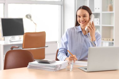 Ofiste telefonla konuşan güzel bir sekreter.