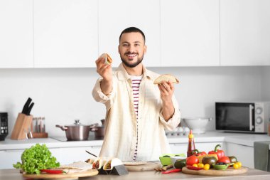 Mutfakta lezzetli Meksika tacoları olan genç bir adam.