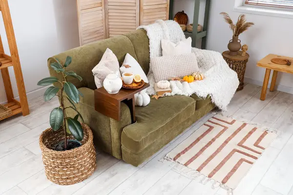 Çaydanlık ve bir fincan yeşil çay oturma odasındaki kanepede.