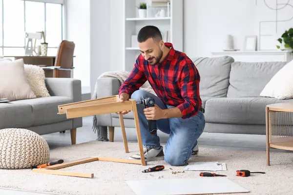 Evinde eğitim masası olan genç bir adam.