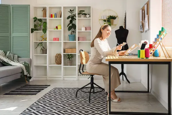 Atölyede masa başında çalışan kadın terzi.