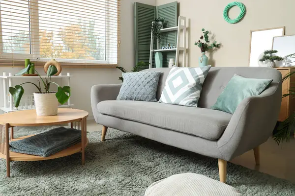 Oturma odasının içinde kanepe, kahve masası ve bitkiler var.