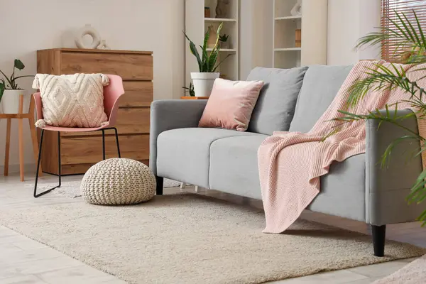 Oturma odasında kanepe, ekose örgü ve sandalye var.