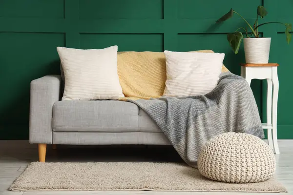Oturma odası, kanepe, örgü battaniye ve puf.
