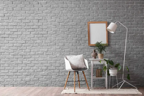 Oturma odasının içinde koltuk, masa ve lamba var.