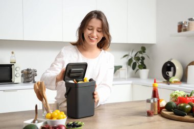 Mutfakta gübre kutusu olan genç bir kadın.