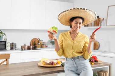 Mutfakta sombrero şapkalı ve lezzetli tacolu genç Afro-Amerikalı kadın.