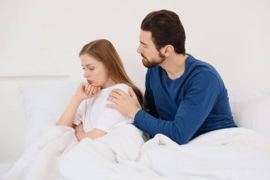 Genç adam yatak odasında karısından özür diliyor.