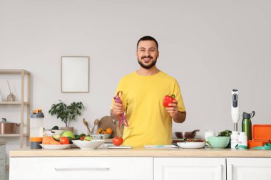 Taze sebzeli, terazili ve bantlı yakışıklı bir genç. Sağlıklı gıda konsepti