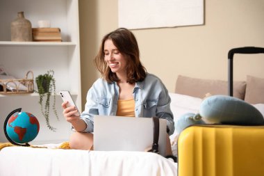 Yatak odasında cep telefonu kullanan bir kadın yolcu. Güzergah kavramı