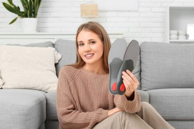 Ortopedik tabanlı genç bir kadın evde oturuyor.