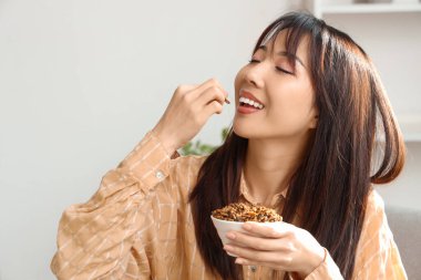 Güzel Asyalı kadın evde kızarmış böcek yiyor, yakın plan.