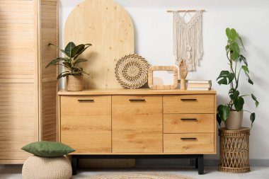 Odanın içinde ahşap tuvalet, katlanır ekran ve bitkiler var.