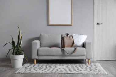 Koridorun içinde, kapısında ve kanepesinde şık bir çanta var.