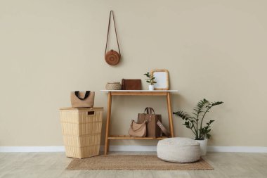 Odanın içinde şık çantalar, masa ve sepet var.