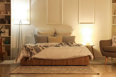 Şık bir yatak odası, rahat bir yatak odası ve akşam lambaları.