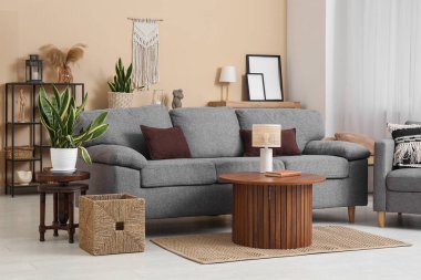 Oturma odasının içinde lamba olan rahat bir kanepe ve kahve masası.