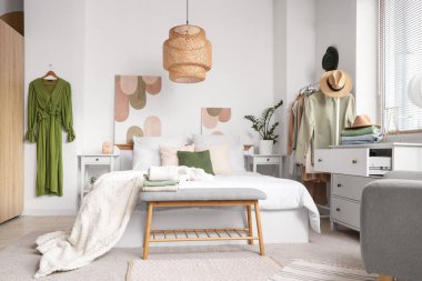 Rahat yataklı yatak odası ve elbiseli askı.