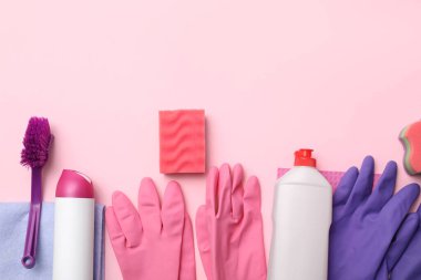 Set of cleaning supplies on pink background