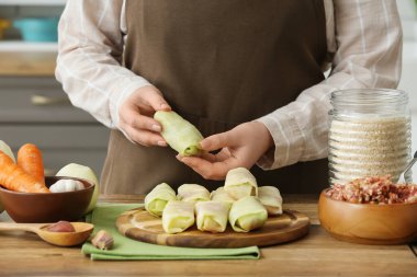 Mutfaktaki masada lahana dolması olan kadın, yakın plan.