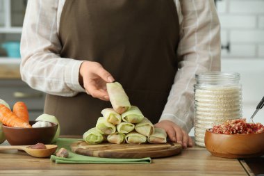 Mutfaktaki masada lahana dolması olan kadın, yakın plan.
