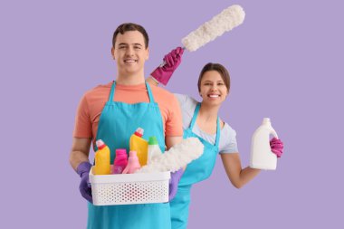 Leylak arka planında temizlik malzemesi olan genç bir çift.