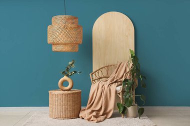 Ekoseli ve okaliptüs dallı, mavi duvarın yanındaki sehpanın üstündeki vazoda.