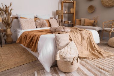 Büyük yataklı, raflı ve banklı rahat bir yatak odası.