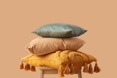 Bej arka planda farklı yastıklı dışkı