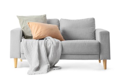 Yastıklı kanepe ve beyaz arka planda battaniye