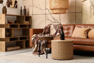 Rahat bir kanepe, raf ünitesi ve şişesi oturma odasının içinde.