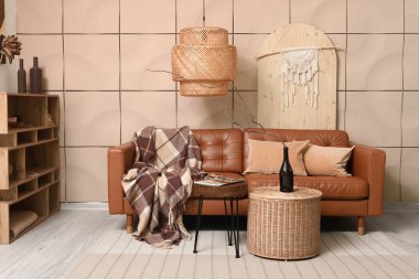 Rahat bir kanepe, kahve masası ve şişesi oturma odasının içinde.