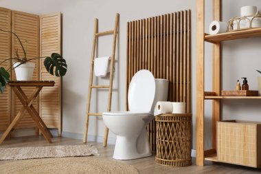 Tuvalet klozeti, merdiveni ve katlanan ekranı olan bir tuvalet.