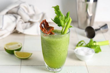 Beyaz fayanslı pastırma ve kerevizle süslenmiş bir bardak Bloody Mary kokteyli.