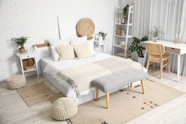 Yatak odasının içi komodinli, yatak masalı, masa ve büyük yataklı.