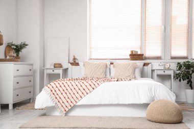 Büyük, rahat bir yatak odası ve yatak odasının içindeki komodinlerde.