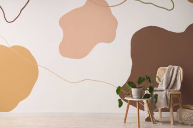 Kahve sehpası, ev bitkisi ve battaniyesi olan rahat ahşap sandalye.