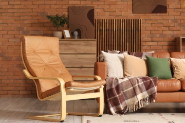 Oturma odasının içinde deri kanepe, koltuk ve tuvalet var.