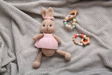 Kareli kumaş üzerinde oyuncak tavşan ve bağcıklar.