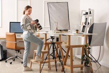 Kameralı kadın fotoğrafçı stüdyoda mücevher fotoğrafı çekiyor.