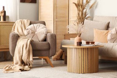 Koltuğu, koltuğu ve masası olan şık bir oturma odası.