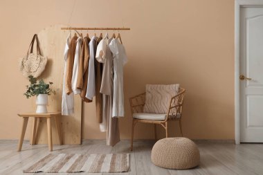 Butiğin içinde elbise askılığı, masa ve koltuk var.