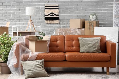 Hareket gününde oturma odasında film, yastık ve karton kutulu kahverengi kanepe.