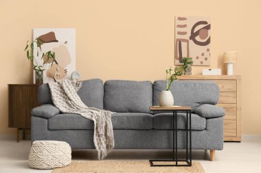 Modern oturma odasının içinde şık posterler ve bambu sapları var.