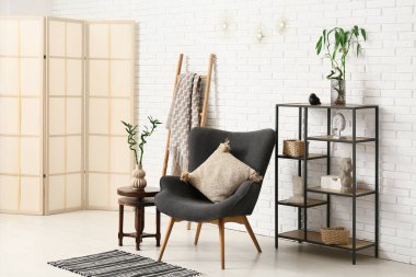 Rahat koltuk ve bambu saplı, hafif oturma odasının şık bir iç mekanı.